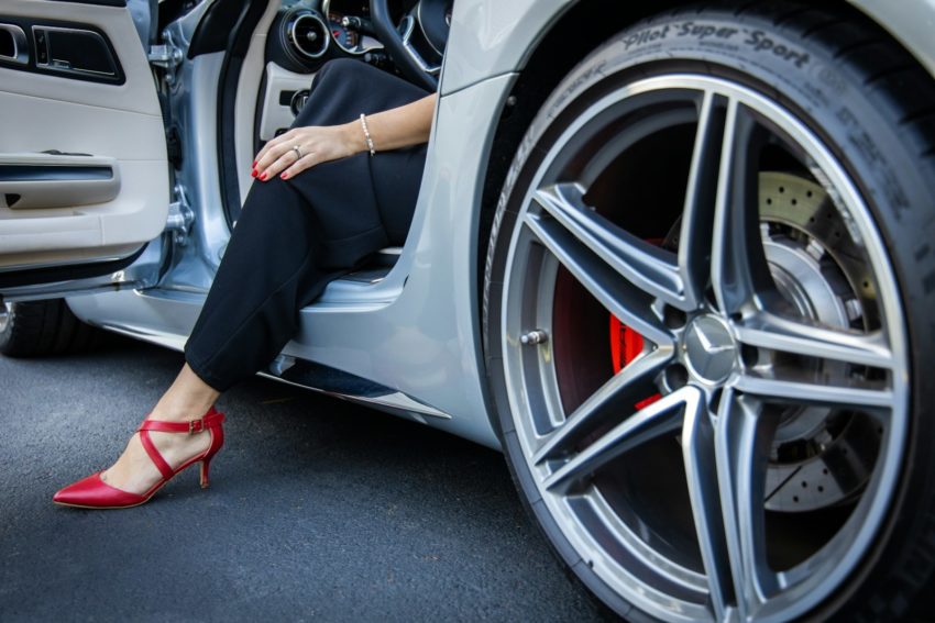 person in black pants sitting on white car